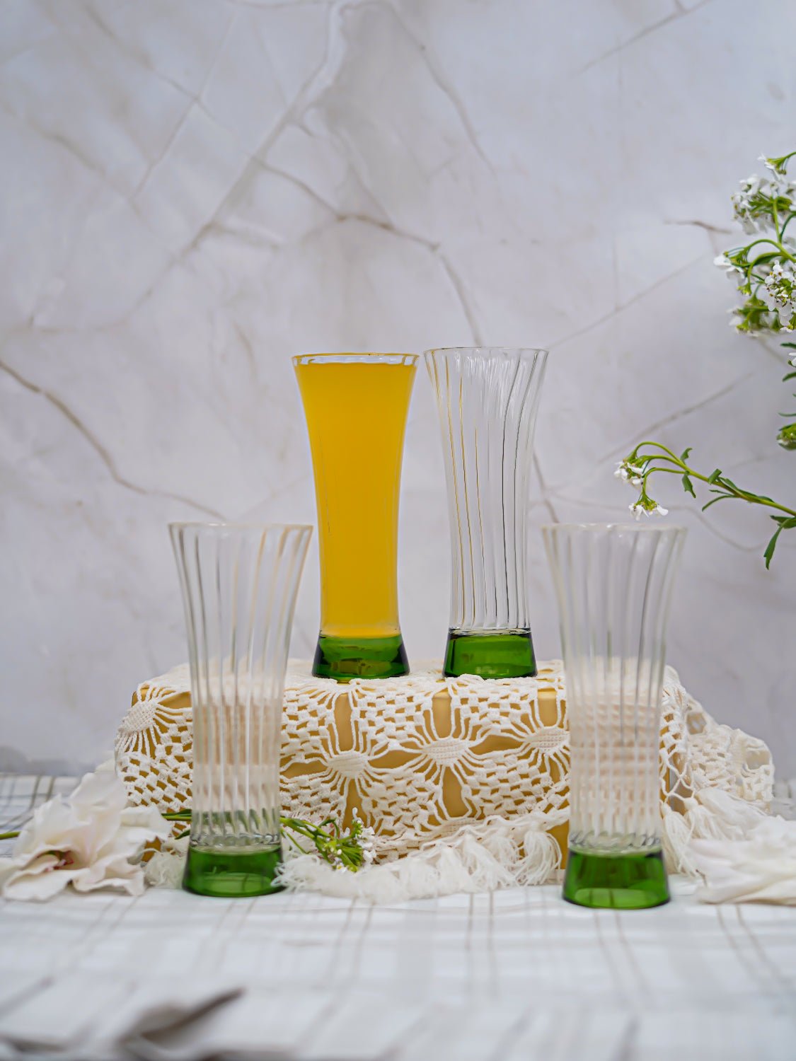 Stylish borosilicate juice glasses with ribbed texture and green base, ideal for home, cafes, or special gatherings.