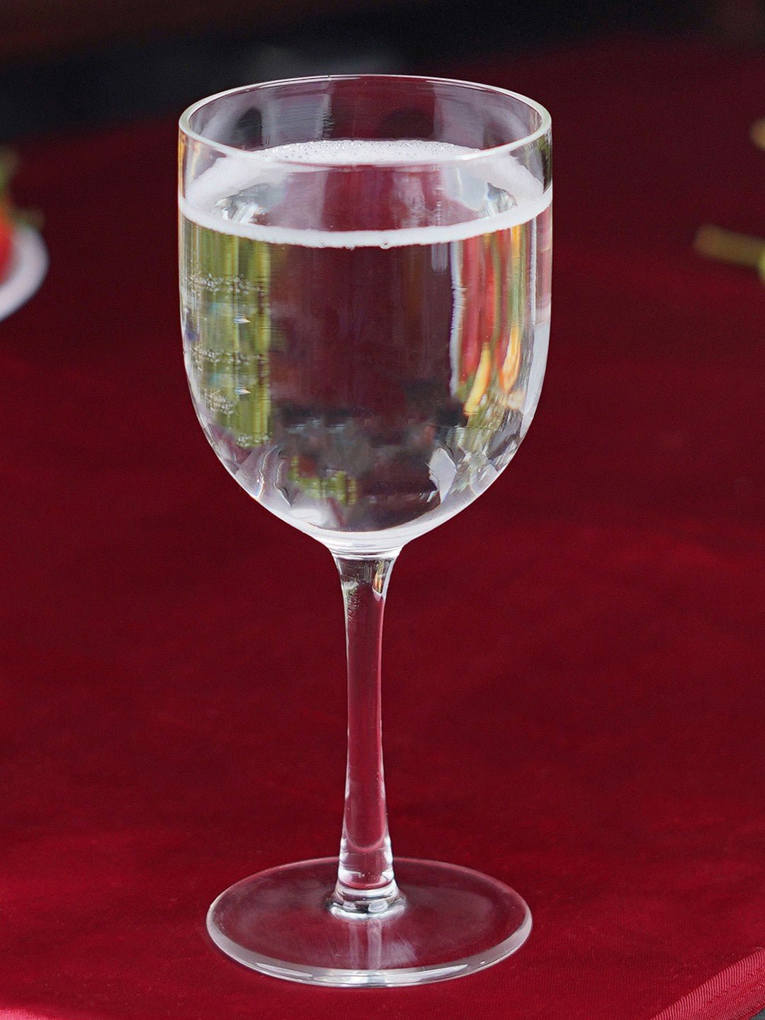 Fine wine poured into a 280ml Prism Hue borosilicate goblet with a green tint, enhancing the drinking experience.